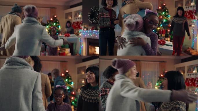 快乐的朋友来拥抱圣诞节，在冬天的晚上在家庆祝圣诞节4k镜头，给家人带来礼物，享受节日庆典