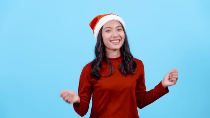 4K，肖像，长发的亚洲女孩红色长袖上衣，戴着圣诞帽，在圣诞节期间与善良共舞，希望能从圣诞老人那里得到