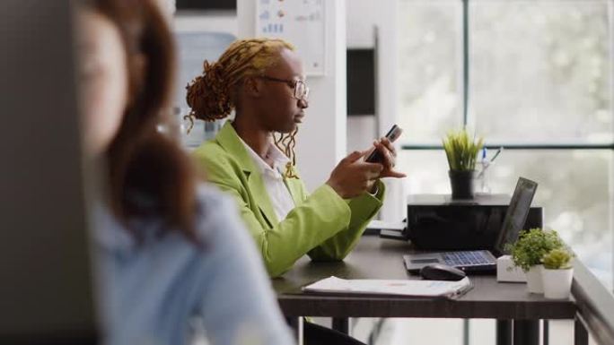 非裔美国工人在休息时使用智能手机应用程序