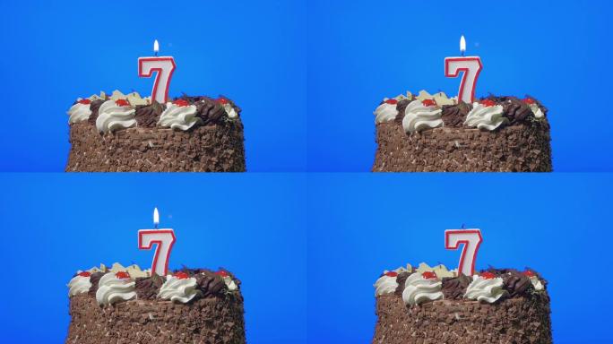 在美味的巧克力蛋糕上吹出七号生日蜡烛，蓝屏