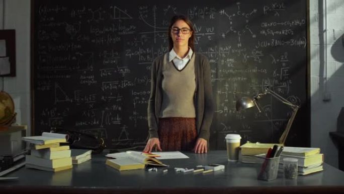 放大: 大学教室里年轻女教师的肖像站在黑板前，用数学公式。大学图书馆的科学女研究员，认真地看着相机