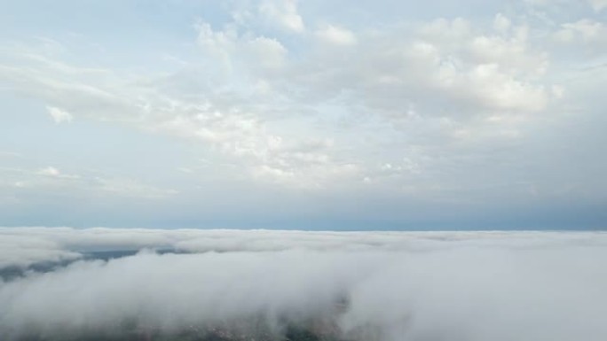 白云蓝天风景鸟瞰图移动。晚上，在明亮的太阳日落雾中，无人驾驶飞机在蓝天中飞出蓬松的云层。自然