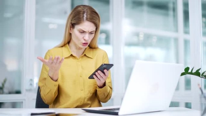 紧张的金发成熟女商人在工作场所因智能手机服务不佳而遇到问题