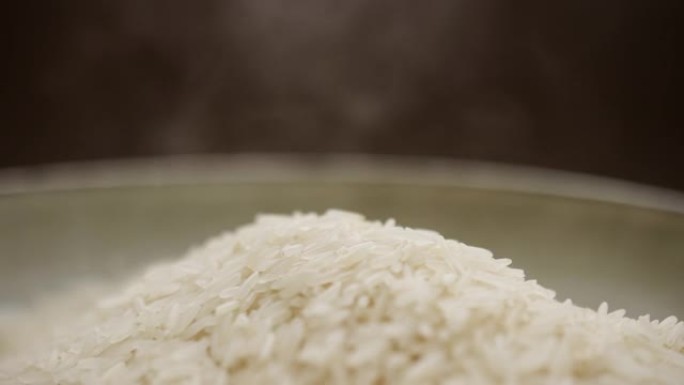 热白泰国茉莉花长粒米，碗中装蒸汽。有机素食健康食品。健康营养菜。关闭慢动作。宏观拍摄。