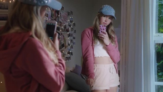 快乐的少女自拍照片使用智能手机在镜子里摆姿势在社交媒体上分享时尚时尚在家享受周末青少年自我形象