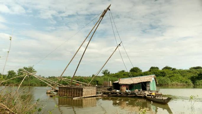 湖上有中国渔网和竹鱼箱的房子船