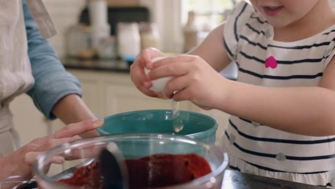 美丽的小女孩帮助妈妈在厨房里烘烤，把鸡蛋打碎成碗里搅拌配料烘烤巧克力蛋糕在家准备食谱