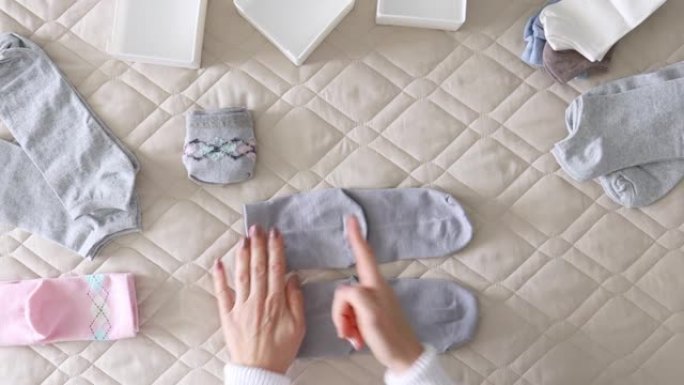 妇女的手折叠袜子以各种方便的方式存放。大师班。