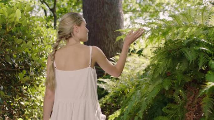 自然女孩走在森林里，年轻女子探索郁郁葱葱的花园，被户外的自然美迷住了