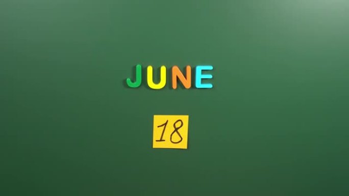 6月18日日历日用手在学校董事会上贴一张贴纸。18 6月日期。6月的第十八天。第18个日期编号。18