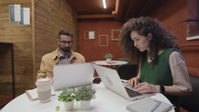 在共享工作区的笔记本电脑上工作的男人和女人