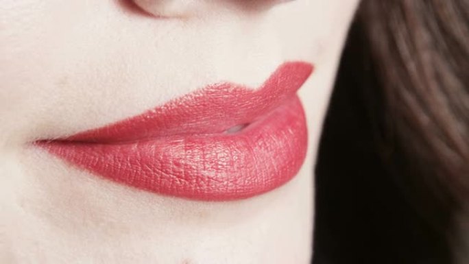 女人的微距嘴唇亲吻咬舌头红色唇膏