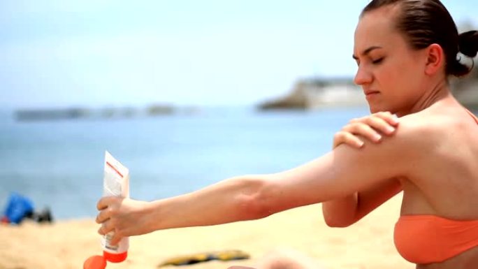 海滩上的女人涂抹乳液