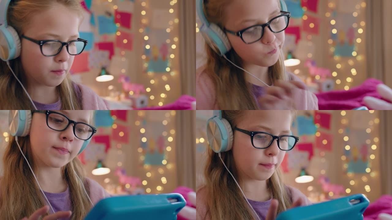 可爱的小女孩用平板电脑听音乐戴着耳机享受在线娱乐孩子在家里用便携式触摸屏设备玩得开心