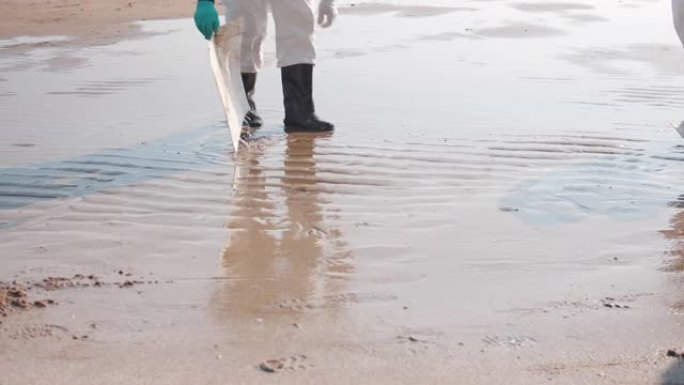 清理海滩上的溢油涨潮退朝清理工清洁工