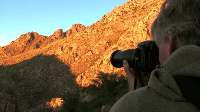 摄影师拍摄阳光照耀的山