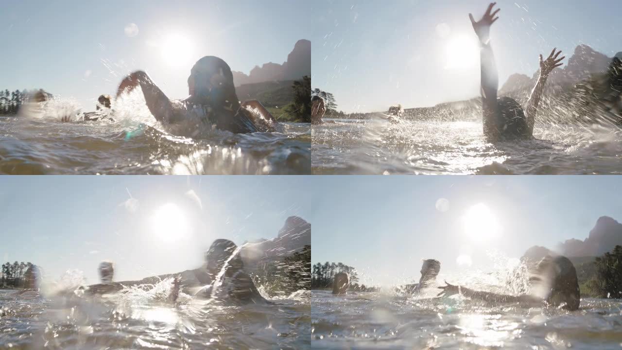 快乐的朋友在日落时在湖里游泳，在水中嬉戏，庆祝夏天享受自由，下午一起游泳