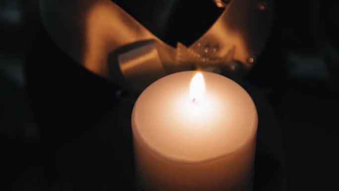 桌子上有一根浓浓的燃烧蜡烛。火焰用温暖的光照亮了空间