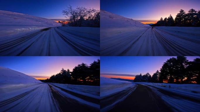 黄昏时在雪山路上行驶。