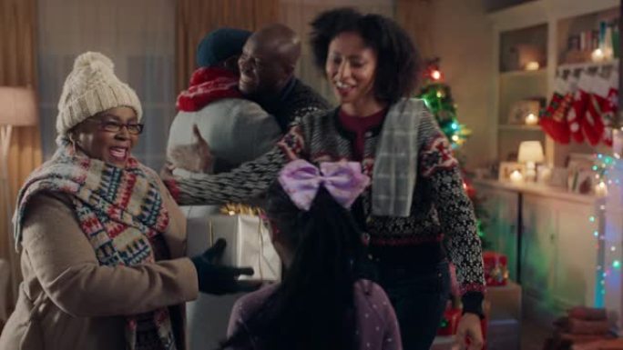 非裔美国祖父母圣诞拥抱家庭赠送礼物，享受冬季晚上在家的节日庆祝活动4k镜头