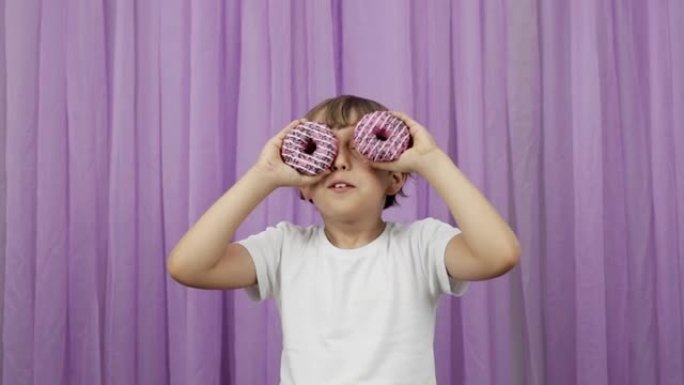 9岁的男孩使用甜甜圈作为眼镜。