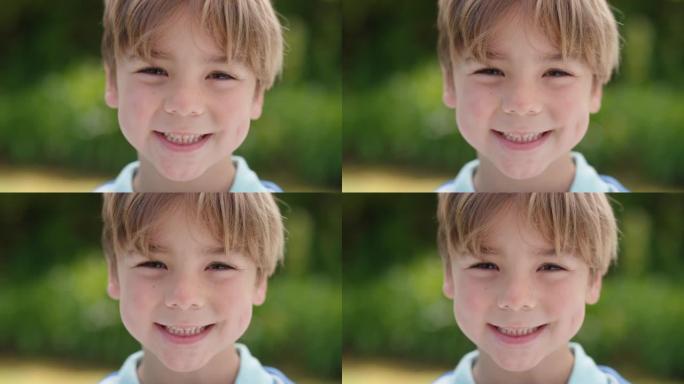 肖像快乐的小男孩带着顽皮的兴奋微笑着看着相机在阳光明媚的公园享受童年的乐趣4k镜头