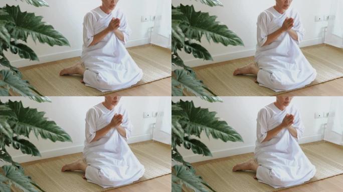 穿着白色礼服的老年人的例行程序一起向佛陀祈祷，退休人员的早晨例行程序。