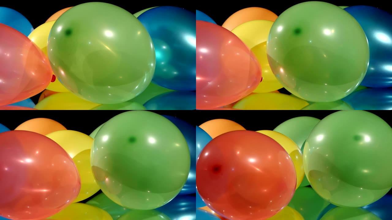 黑色背景上的彩色不同气球，旋转