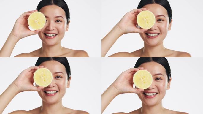 柠檬护肤，工作室里的脸和女人，自然健康和白色背景。快乐的亚洲模特，美容肖像和柑橘类水果，用于面部化妆