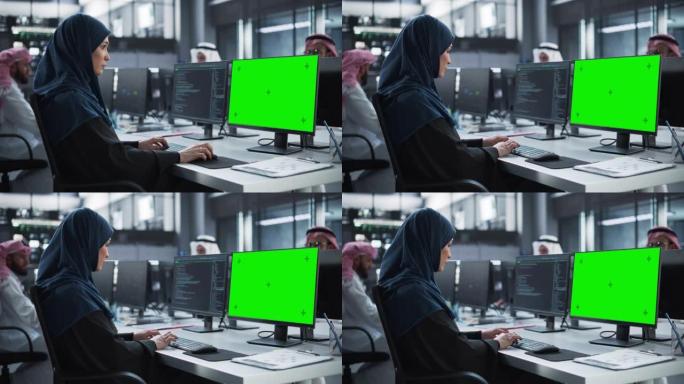 阿拉伯女性软件开发人员在具有绿屏模拟显示的台式计算机上工作。年轻的中东专家测试创新金融科技项目的编程