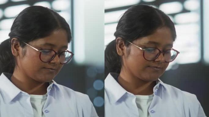 垂直屏幕: 技术软件工程部经理站立并使用笔记本电脑的肖像。印度女性在办公室工作时专注于思考