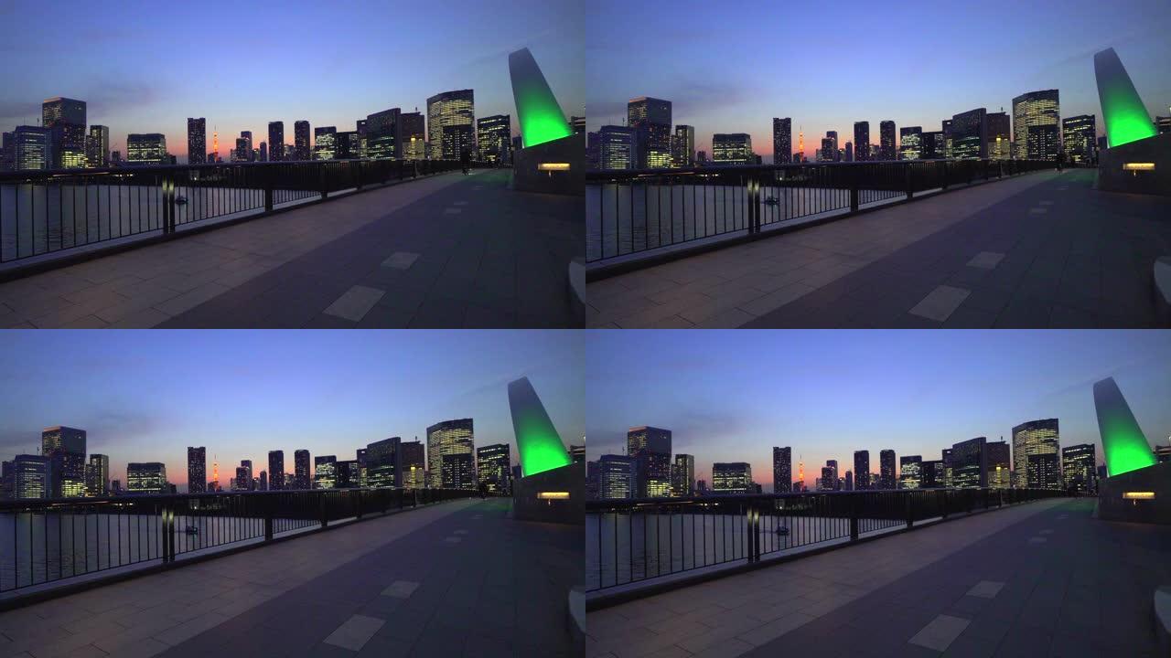 东京铁塔和黄昏时的城市景观。穿越筑地大桥的自行车。