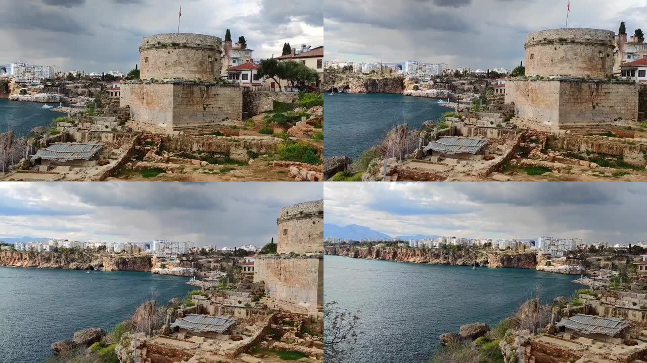 土耳其安塔利亚的一座古老的石头堡垒，以古老的废墟为背景，位于蓝色的地中海之滨