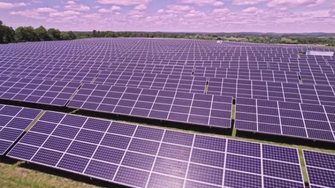 现代光伏太阳能电池板为电池充电的鸟瞰图。飞越农田上设置的一排排可持续能源太阳能电池板。绿色能源与环境