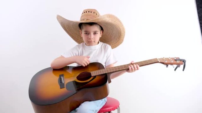 可爱的小孩手指弹吉他的特写。儿童音乐学校。音乐和弦。