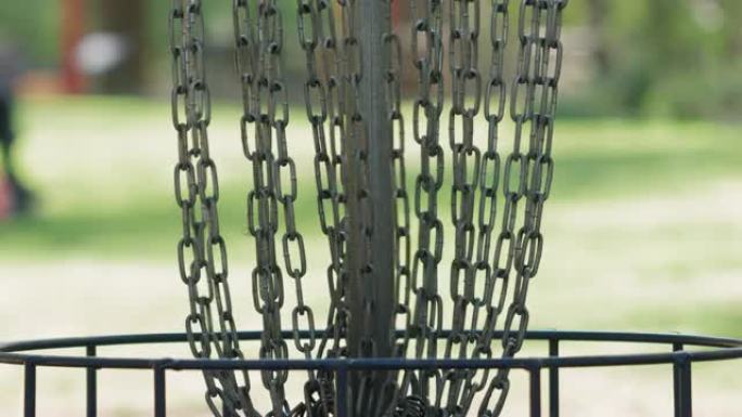 飞盘击中圆盘高尔夫球场的金属链篮