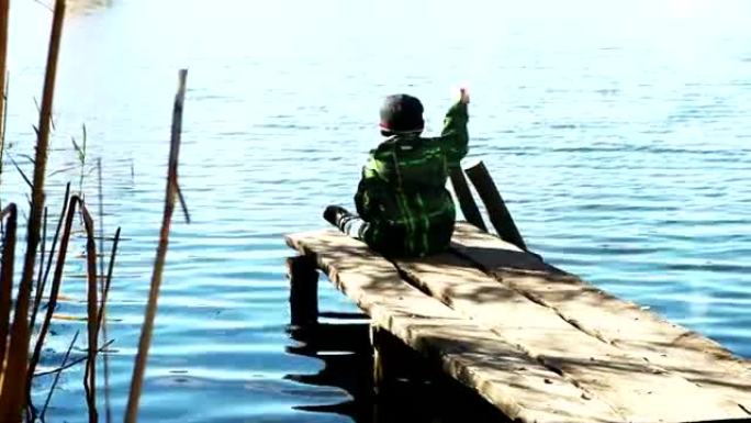 独自男孩在湖水里扔石头