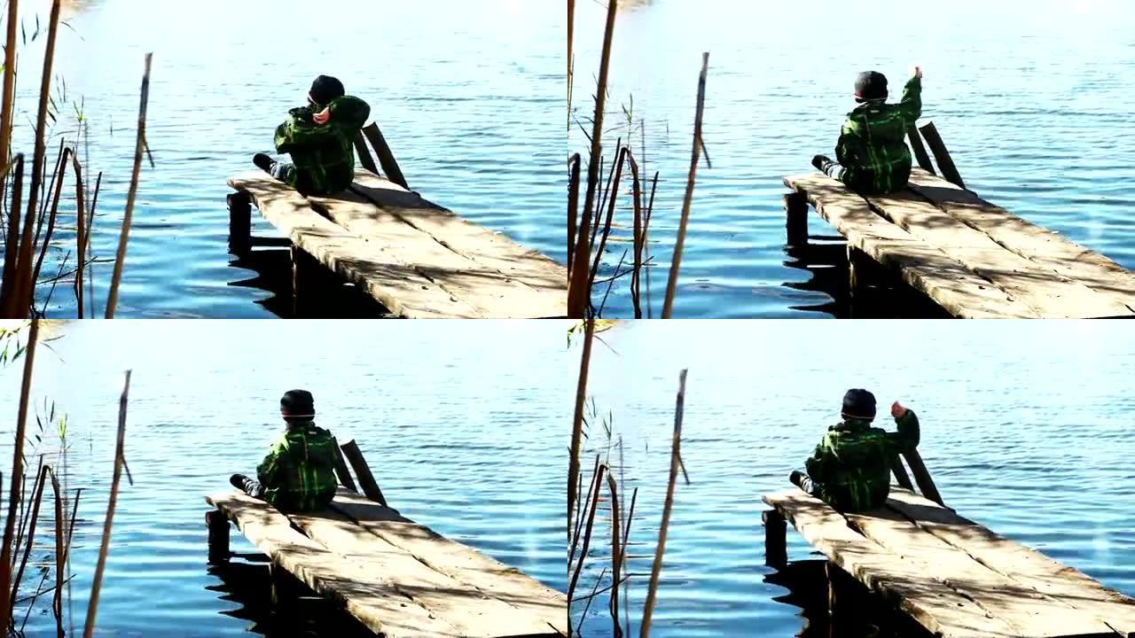 独自男孩在湖水里扔石头
