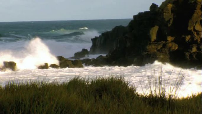 海浪在岩石岬角上坠毁，造成喷雾