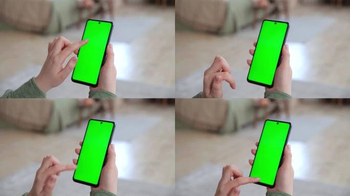 后视图的年轻女子拿着智能手机与绿色屏幕的复制空间，进行点击，滑动和滚动。广告、社交网络、新闻的色键模