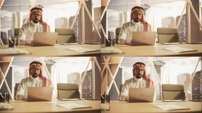 一位穆斯林商人在金融科技初创公司的笔记本电脑上工作的肖像。阿拉伯金融分析师在新兴的中东股票市场进行研