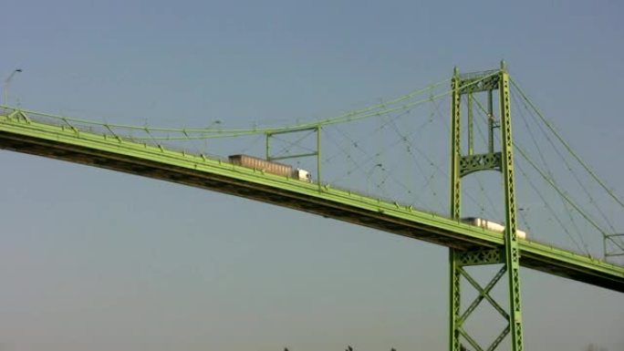 绿色悬索桥，带过往卡车。