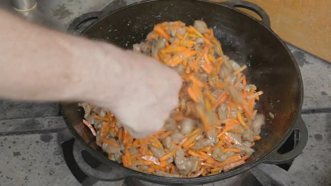 编辑用开槽勺子切成薄片的猪肉和胡萝卜