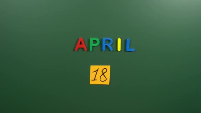 4月18日日历日用手在学校董事会上贴一张贴纸。18 4月日期。4月的第十八天。第18个日期编号。18