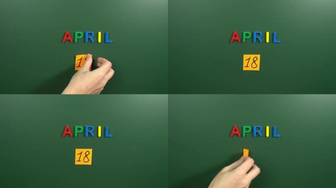 4月18日日历日用手在学校董事会上贴一张贴纸。18 4月日期。4月的第十八天。第18个日期编号。18