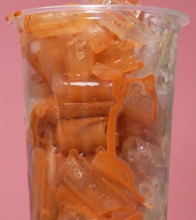 将Lced茶倒入装满冰的透明玻璃杯中。
