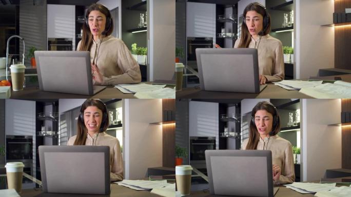 年轻的商业女性使用笔记本电脑与同事或合作伙伴进行视频电话会议。女经理在家厨房远程工作，在网上做演示