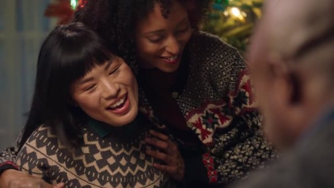 美丽的亚洲女人与非洲裔美国家庭最好的朋友一起庆祝圣诞晚餐，拥抱在家里享受节日假期4k