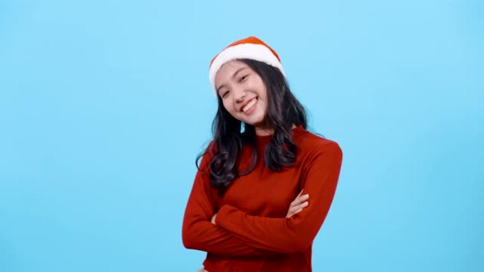 4K，肖像，长发的亚洲女孩红色长袖上衣，戴着圣诞帽，舞蹈将双手放在胸前，快乐的方式，孤立的室内工作室
