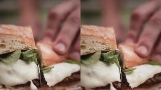 多汁三明治的垂直视频，手中的肉分为两部分